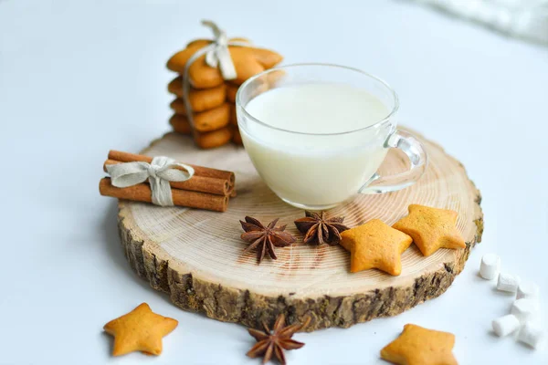 Рождественские пряники, молоко, какао, зефир, корица, конфеты на деревянной тарелке у окна — стоковое фото