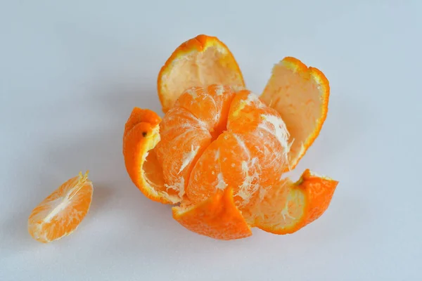 Peeled tangerine on a white background.Orange fruits and peeled segment Isolated. Pile of orange segments — Stock Photo, Image