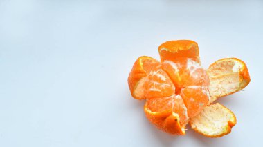 Beyaz arka planda soyulmuş mandalina. Portakal meyveleri ve soyulmuş bölüm izole edildi. Turuncu kesitler yığını