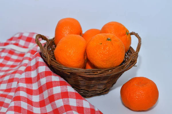 Tangerinas suculentas maduras em uma cesta de tecido de madeira em um fundo branco — Fotografia de Stock