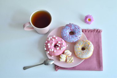 Pembe tabakta çok renkli çörekler