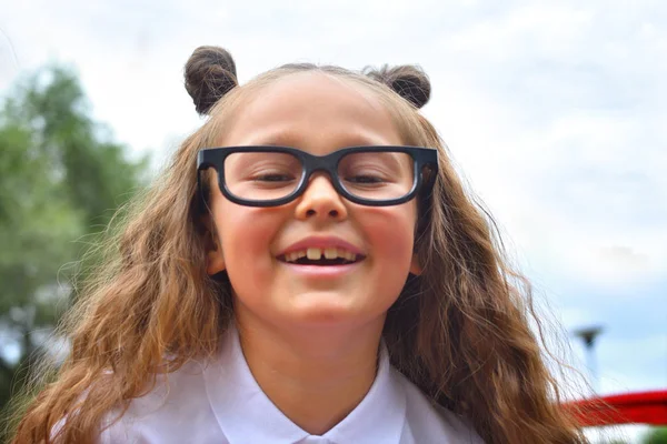 Retrato de una hermosa joven de primer grado en gafas. Enfoque en las niñas ojos — Foto de Stock