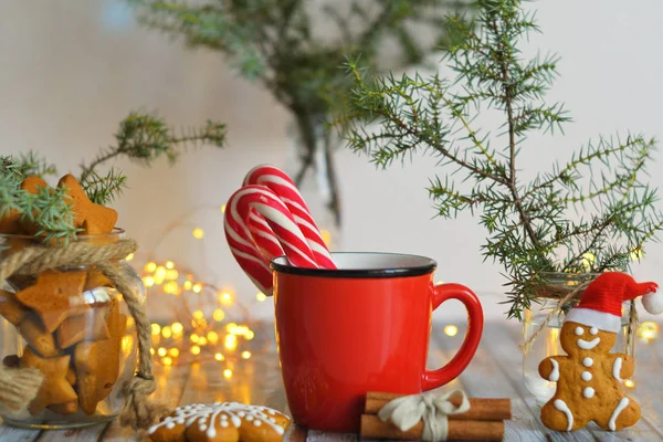 Cacao o chocolate caliente con malvavisco sobre mesa rústica. Composición de Navidad o Año Nuevo. Hombre de jengibre con bastón de caramelo. Vista cercana de malvavisco en taza roja con espumoso. enfoque selectivo suave . — Foto de Stock