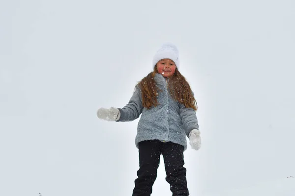 冬の外を歩く幸せな子供の女の子。冬休みに遊ぶ小さな子供。冬の湖の少女 — ストック写真