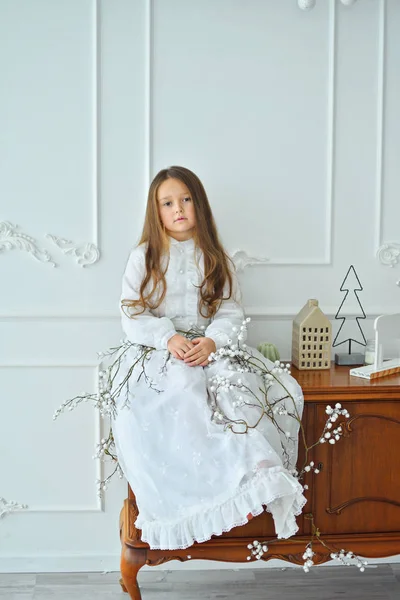 Jolie fille aux cheveux longs dans une robe rétro blanche et avec un décor de Noël. Bonne année — Photo