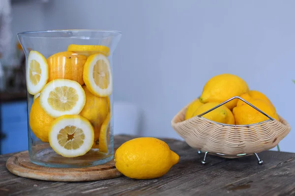 Limón en plato de madera sobre mesa de madera. Limones en rodajas. Fondo gris, cítricos, vitamina C — Foto de Stock