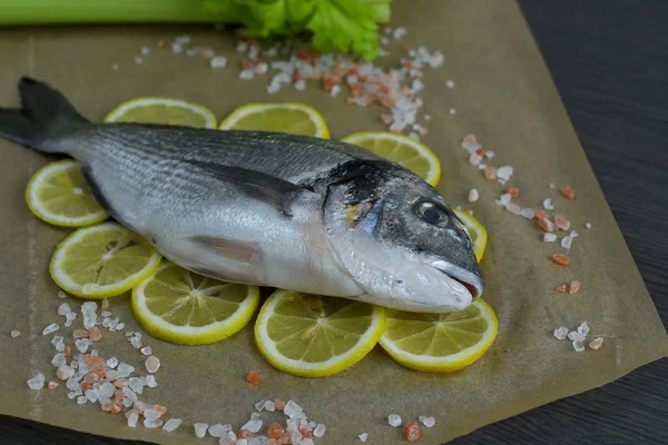 Peixe cru dorada.Filé de peixe cru em fatias de limão no fundo escuro pronto para cozinhar, fundo de comida. vista superior. Conceito de alimentação saudável. Marisco mediterrânico. sargo marinho dourado — Fotografia de Stock