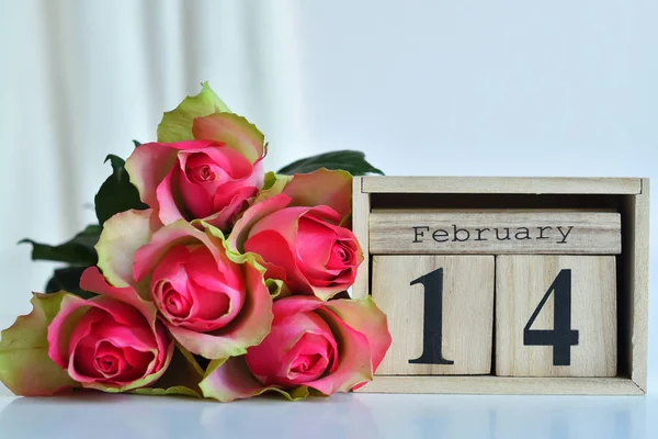 14 februari tekst op houten blokkenkalender en roze rozen. Valentijnskaart.Sjabloon wenskaart voor Valentijnsdag. Wenskaart metroze rozen .kopieer ruimte. — Stockfoto