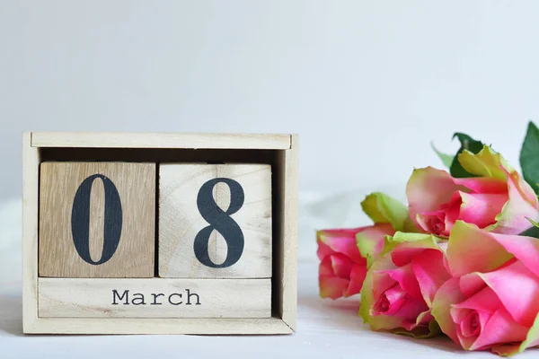 8 maart tekst op houten blokkenkalender en roze rozen. Wenskaart met roze rozen Spring kaart template. Vrouwendag. Wenskaart voor moederdag. Bloemenkaart. Kopieerruimte. — Stockfoto