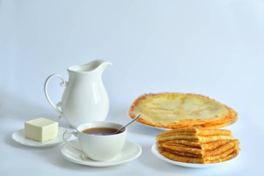 Pancake week: thin pancakes with butter and tea on white table.french crepes .Delicious breakfast.Selective focus