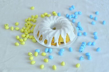 Beyaz arka planda izole edilmiş Paskalya pastası. Paskalya arkaplanı, sarı ve mavi boyalı yumurtalar davetiye kartı tasarımı ve fotokopi alanı. Paskalya kartı şablonu. Seçmeli odak kopyalama bölmesi