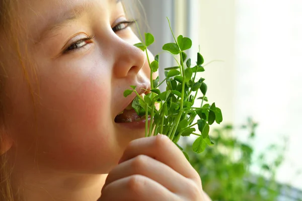 快乐的女孩吃豌豆微绿色 素食的概念 胃口好 在亚麻布垫子上 从高质量的有机植物种子中发芽的发芽蔬菜 — 图库照片