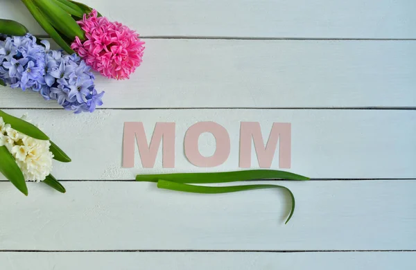 MOM word made with flower petals and leaves. Mother\'s day natural creative concept background. Copy space