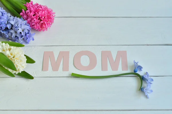 MOM word made with flower petals and leaves. Mother\'s day natural creative concept background. Copy space