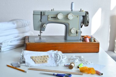 Ev yapımı tıbbi maske. Evde virüs maskesi dikiyorum. Dikiş makinesinin detayları. CORONAVIRUS DURUŞU Odaklanma Harfi