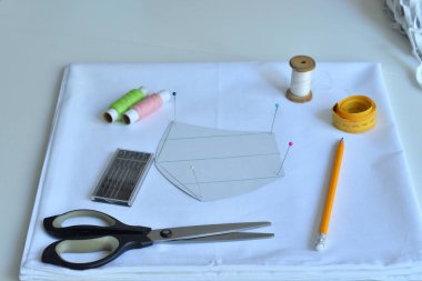 Ev yapımı tıbbi maske. Evde virüs maskesi dikiyorum. Dikiş makinesinin detayları. CORONAVIRUS DURUŞU Odaklanma Harfi