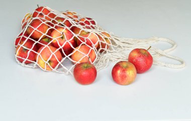 Kırmızı elmalarla dolu bir tekstil çantası. - Sıfır yiyecek alışverişi. Beyaz arka planda eko doğal torbalar. Çevre dostu kavram. Plastiksiz minimalist yaşam tarzı. Yeniden kullan, azalt, geri dönüştür. Plastiğe hayır de.