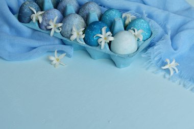 Paskalya arkaplanı mavi yumurtalar ve bahar çiçekleri... Mutlu Paskalya Bayramı Şenlik Kartı. Tatillerde doğal olarak mermer taşlı amber çiçeğiyle boyanmış yumurtalar. kopyalama alanı. Seçici odak