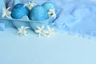 Paskalya arkaplanı mavi yumurtalar ve bahar çiçekleri... Mutlu Paskalya Bayramı Şenlik Kartı. Tatillerde doğal olarak mermer taşlı amber çiçeğiyle boyanmış yumurtalar. kopyalama alanı. Seçici odak