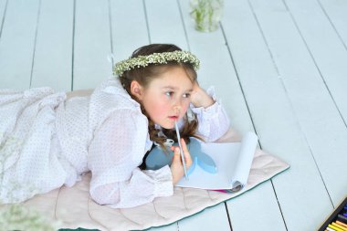 Kız paskalya tavşanını kağıda çiziyor. Paskalya hazırlığı. Tavşan kulaklı sevimli komik kız. Paskalya konsepti. Yumurta avında gülen çocuk