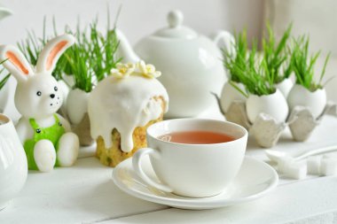 Çiçekli Paskalya pastası, bir fincan çay ve zencefilli ekmek. Tatil kahvaltısı konsepti. Paskalya tebrik kartı şablonu. Ev yapımı pasaport. Beyaz arka planda Paskalya tatlısı. Kopya alanı.