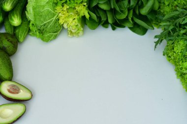 Taze ıspanak, roka, marul salatası, beyaz arka planda avokado. Taze çiğ sebze ve sebze. Spreyliyorum avitaminosis. Smoothie Macro için malzemeler. Seçici odaklanma. Düz yatıyordu
