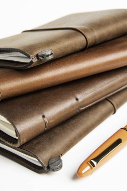 Leather-Bound Journals And An Orange Fountain Pen clipart