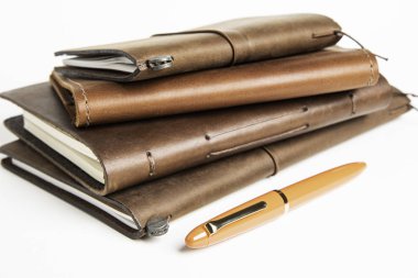 Leather-Bound Journals And An Orange Fountain Pen clipart