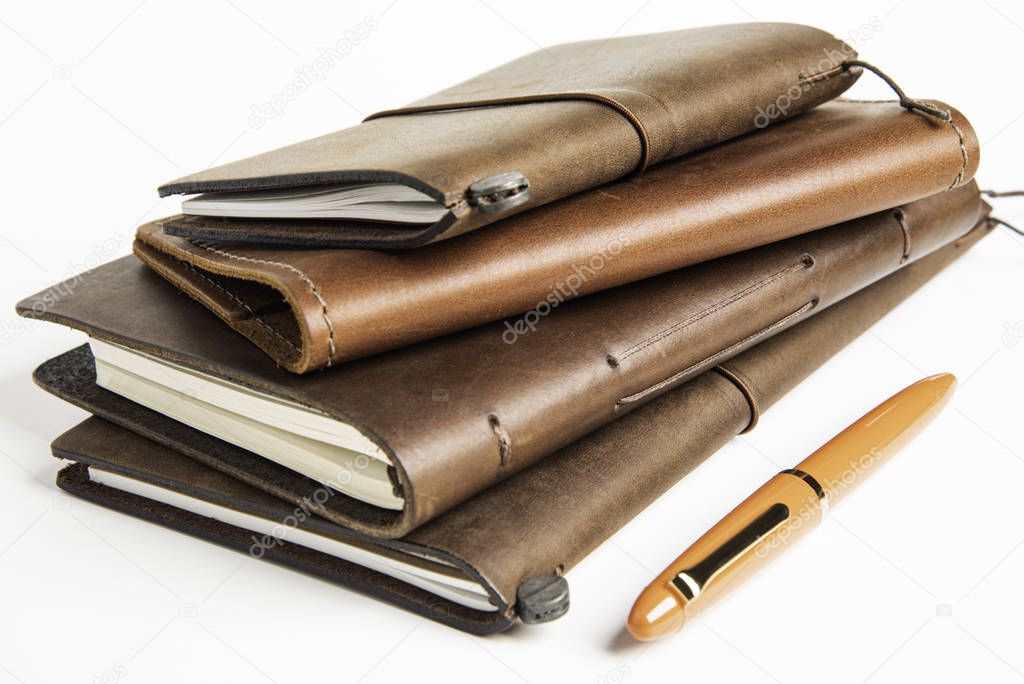 Leather-Bound Journals And An Orange Fountain Pen