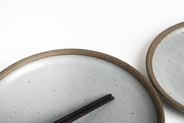 A Pair Of Chopsticks With Stoneware Plate clipart
