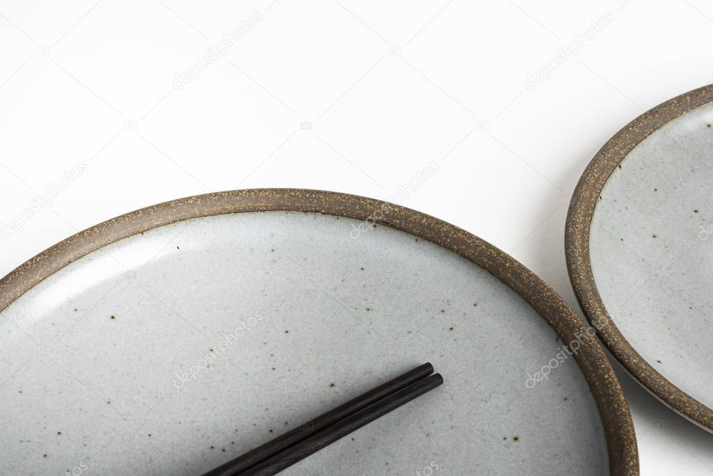 A Pair Of Chopsticks With Stoneware Plate