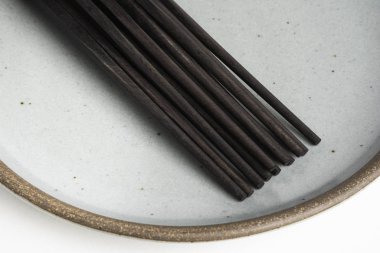 Six Pairs Of Chopsticks On Stoneware Plate clipart