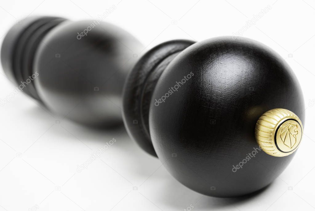 Vidalia, Georgia / USA - June 12, 2019: A stylized extreme macro shot with selective focus on the iconic logo crown of the classic black wood Peugeot pepper grinder.