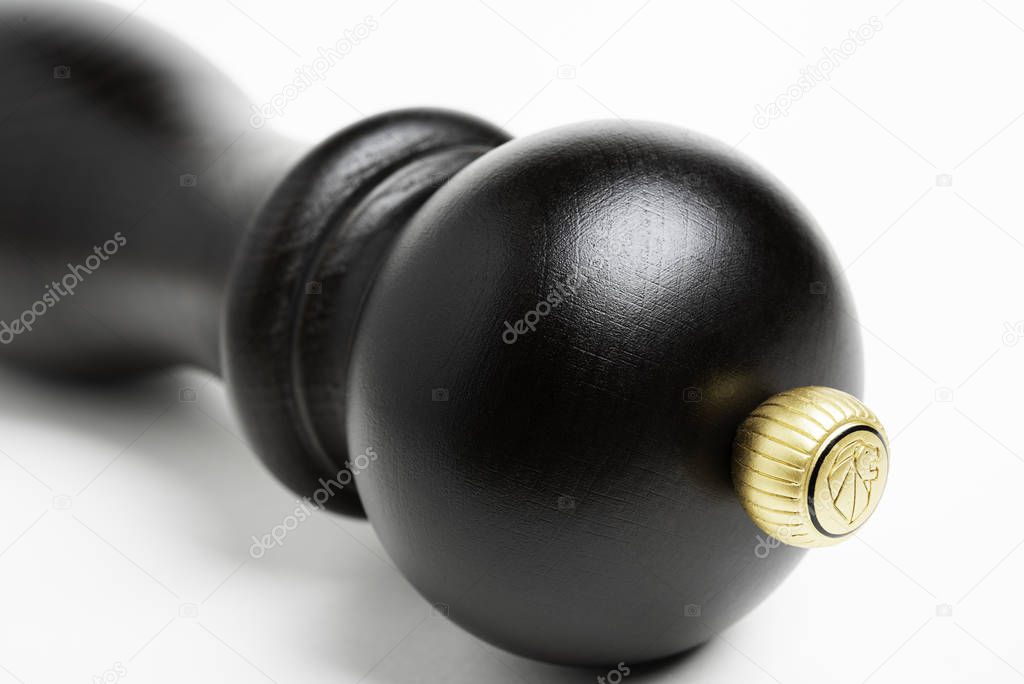 Vidalia, Georgia / USA - June 12, 2019: A stylized extreme macro shot with selective focus on the iconic logo crown of the classic black wood Peugeot pepper grinder.