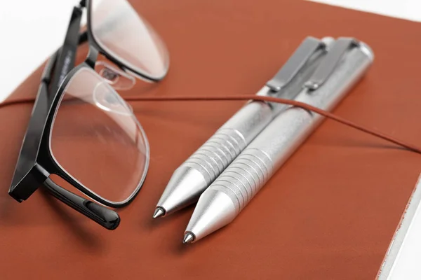 Kalem ve gözlüklü kırmızı deri günlük kapağı — Stok fotoğraf