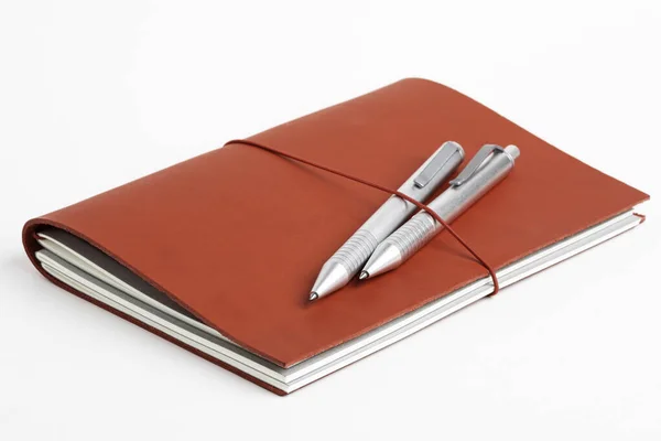Couverture de journal en cuir rouge avec deux stylos à bille — Photo