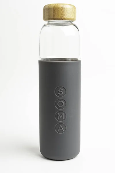 Una botella de agua de vidrio SOMA con manga de silicona gris — Foto de Stock