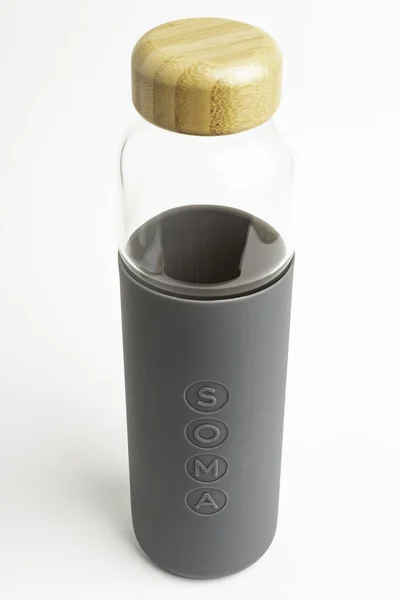 Una botella de agua de vidrio SOMA con manga de silicona gris — Foto de Stock