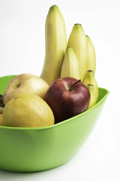 りんごやバナナ オレンジなど 鮮やかで熟した果物を平白地にアレンジした鮮やかな緑色のプラスチック製のボウル — ストック写真