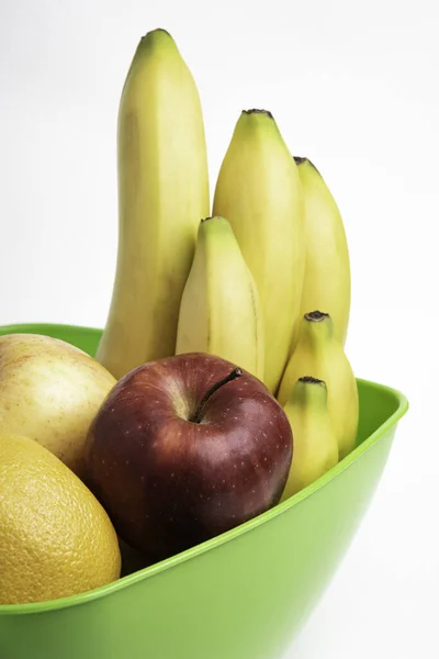 りんごやバナナ オレンジなど 鮮やかで熟した果物を平白地にアレンジした鮮やかな緑色のプラスチック製のボウル — ストック写真
