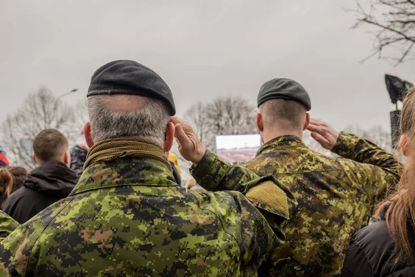 Canadian Army soldiers stand and watch the parade. Military in camouflage. Warrior clothes. Autumn. It\'s a nasty day.