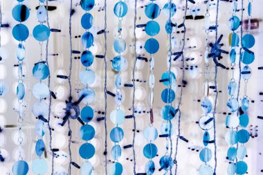 Çelenklerdeki mavi toplar iç mekanı süslüyor. Yeni yıl ve Noel 'i kutlamak için şenlikli kıyafetler. Turkuaz ve beyaz renklerde soyut arkaplan. Dairelerin ve çizgilerin dokusu.