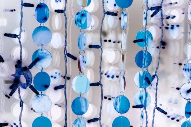 Çelenklerdeki mavi toplar iç mekanı süslüyor. Yeni yıl ve Noel 'i kutlamak için şenlikli kıyafetler. Turkuaz ve beyaz renklerde soyut arkaplan. Dairelerin ve çizgilerin dokusu.