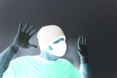 Coronavirus 'tan korunan bir adamın portresi. Beyaz, lateks eldivenler. Enfeksiyonlara, virüslere, mikroplara karşı el koruması. Deride izolasyon. Yüzünde kumaş bir maske var. Gözlerde gözlük.. 