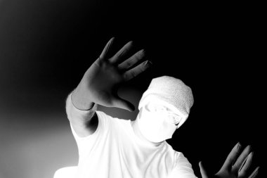 Coronavirus 'tan korunan bir adamın portresi. Beyaz, lateks eldivenler. Enfeksiyonlara, virüslere, mikroplara karşı el koruması. Deride izolasyon. Yüzünde kumaş bir maske var. Gözlerde gözlük.. 