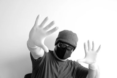 Coronavirus 'tan korunan bir adamın portresi. Beyaz, lateks eldivenler. Enfeksiyonlara, virüslere, mikroplara karşı el koruması. Deride izolasyon. Yüzünde kumaş bir maske var. Gözlerde gözlük.. 