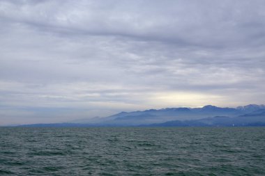 Kafkasya 'nın eteklerinin manzarası. Batumi ilçesi. Yüksek tepelerde kar yatıyor. Alt dağlarda yerleşim yerleri var. Arazinin rengi farklı..