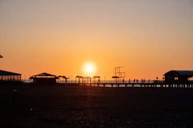  Karadeniz 'de gün batımı. İnsanlar sahilde ve rıhtımda yürüyor. Sessiz, sakin bir akşam..