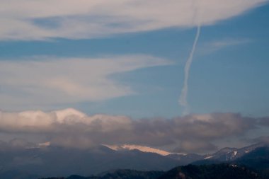Kafkasya 'nın eteklerinin manzarası. Batumi ilçesi. Yüksek tepelerde kar yatıyor. Alt dağlarda yerleşim yerleri var. Arazinin rengi farklı..