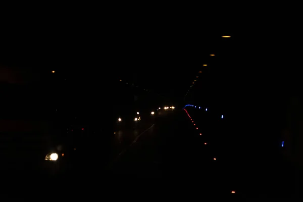 トンネル内のランプや車からの光 暗闇の中の提灯からの光 多色ドットの黒の背景 — ストック写真